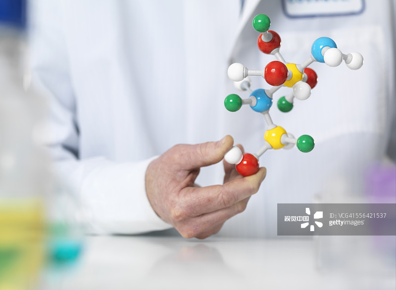 Scientist holding a molecular model of a chemical formula图片素材