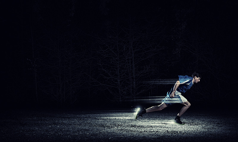跑步的人在蓝色运动服在黑色的背景。全速图片下载
