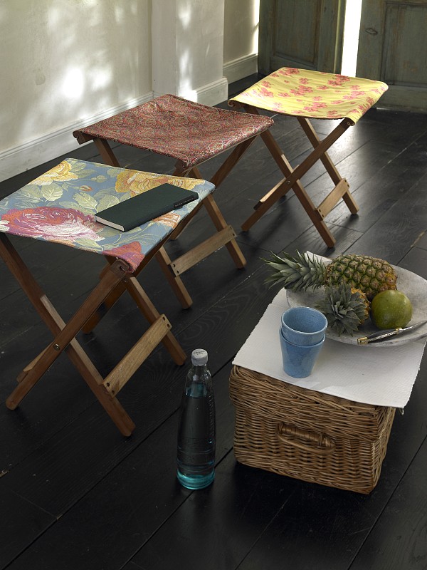 木质地板上的折叠凳子，上面覆盖着色彩鲜艳的织物和水果篮图片下载