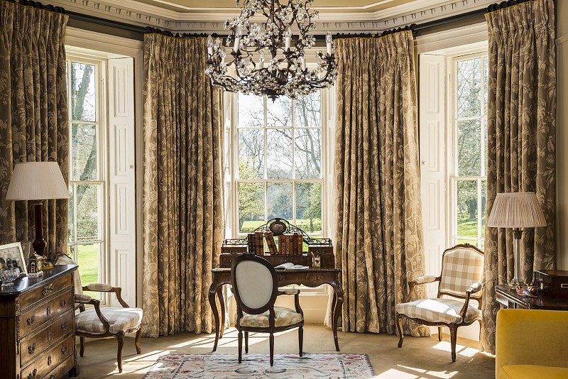 经典的书桌和巴洛克式椅子在窗湾与格子窗和华丽的窗帘图片素材