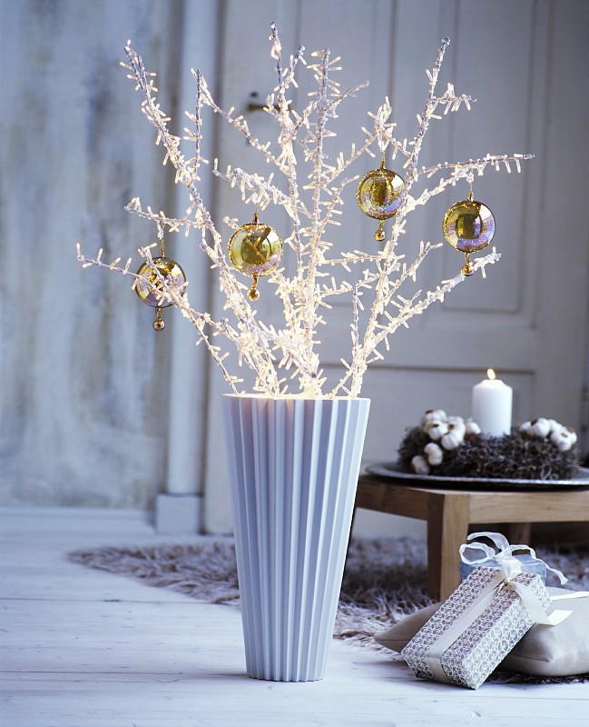 缀满仙女灯的小树枝和花瓶上的小装饰品图片素材