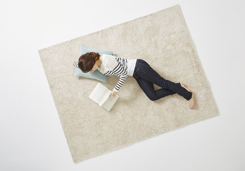 女人躺在地毯上看书的照片摄影图片下载