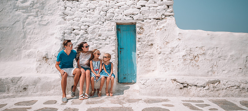 在希腊米科诺斯岛上典型的希腊传统村庄的街道上，父母和孩子们图片素材