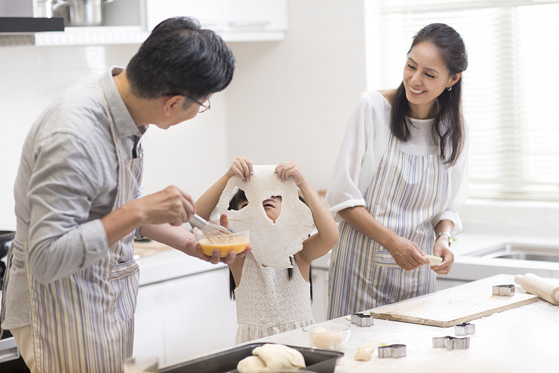 快乐小女孩和爷爷奶奶在厨房制作饼干图片素材