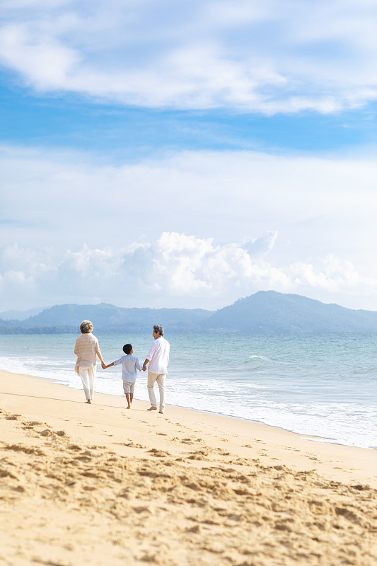快乐的家庭在沙滩漫步图片下载