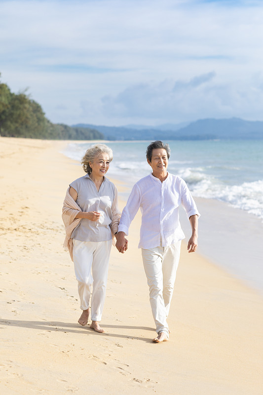 快乐的老年夫妇在沙滩散步图片素材