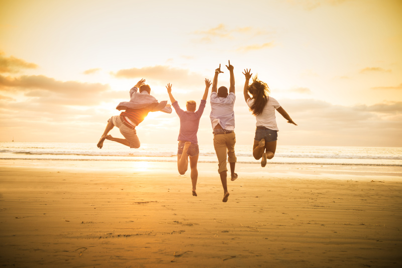 美国加州圣地亚哥，一群年轻人在Mission海滩上跳跃图片素材