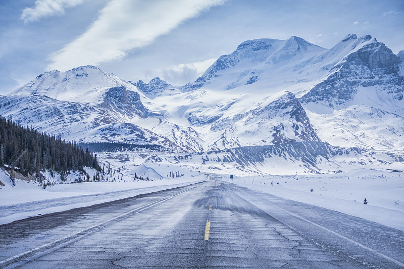 雪山越过田野和结冰的道路图片素材