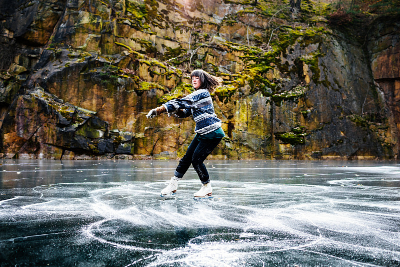 花样滑冰运动员在冰冻的湖面上旋转图片下载