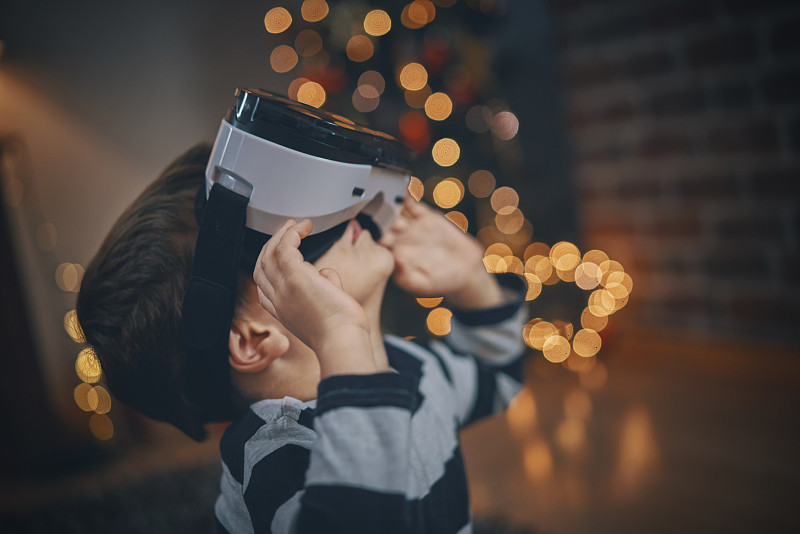 在舒适的圣诞氛围中，孩子们在客厅玩VR眼镜图片下载
