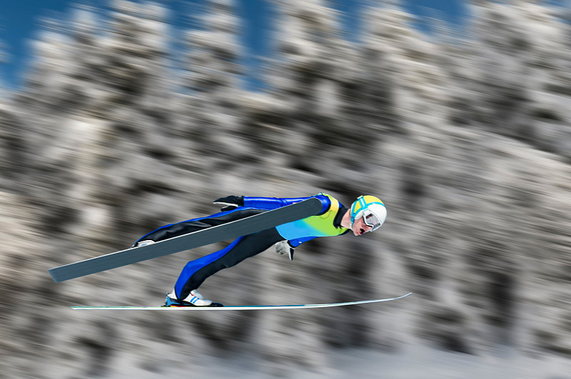 滑雪跳台在半空中对模糊的背景图片下载