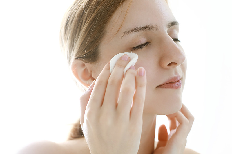 女士将洁面乳涂抹于面部，使用化妆棉图片下载