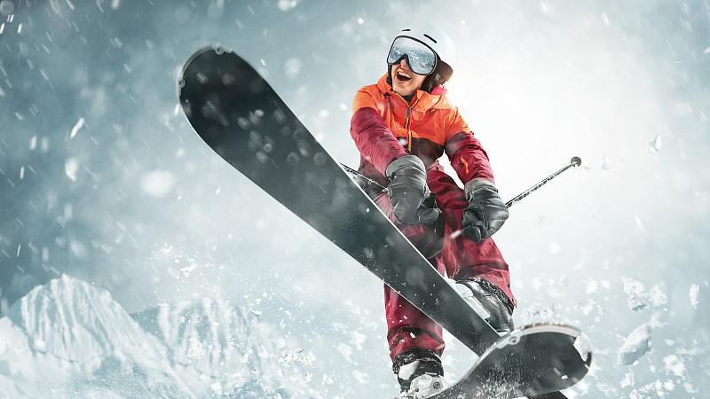 年轻女子和冬季运动-她在白色阿尔卑斯山脉滑雪图片素材