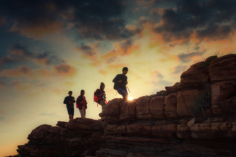 一群青少年朋友步行去爬山。团队合作的概念有助于成功，赢家和领导的概念图片下载