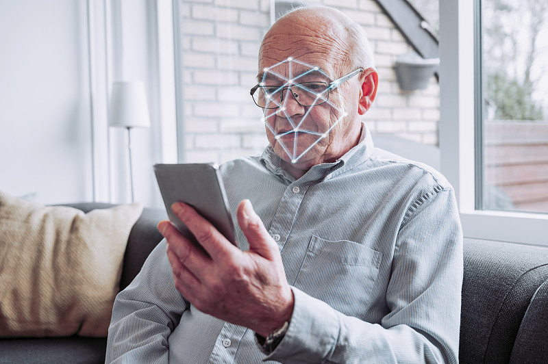 智能手机上的安全软件对老年人进行面部识别扫描图片素材