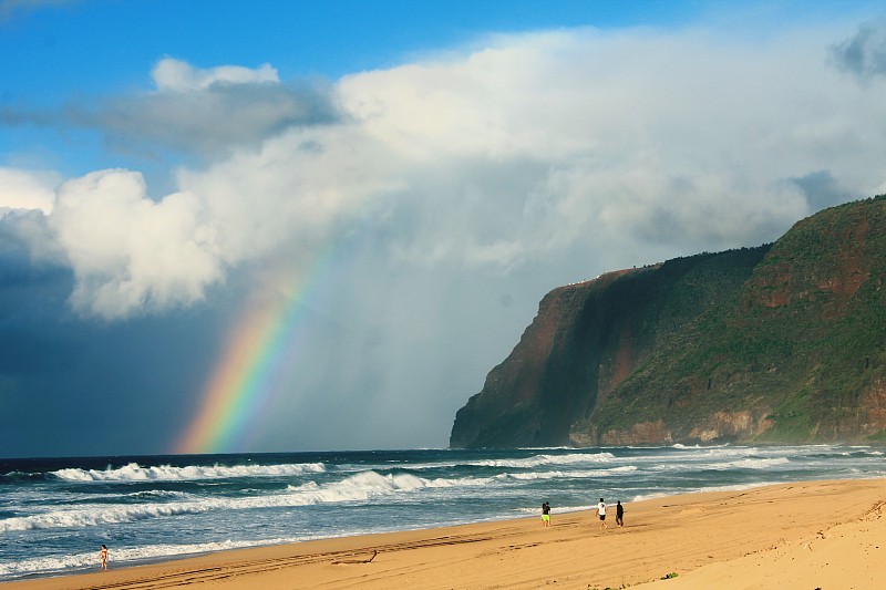 天空中彩虹映衬的海滩风景图片下载