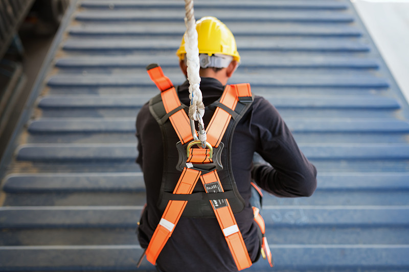 建筑工人在高空作业时佩戴安全带和安全绳图片下载