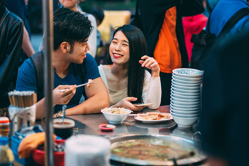 可爱的年轻亚洲夫妇在台北夜市享受街头小吃。图片下载