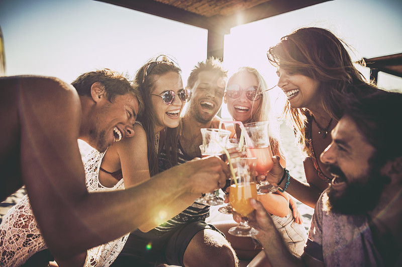 夏日里，一大群欢快的朋友在鸡尾酒中举杯畅饮。图片素材