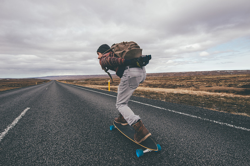 男子在高速公路上玩滑板图片素材