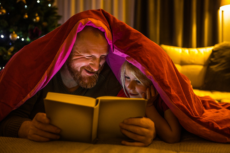 圣诞书阅读为父亲和女儿在圣诞家图片下载