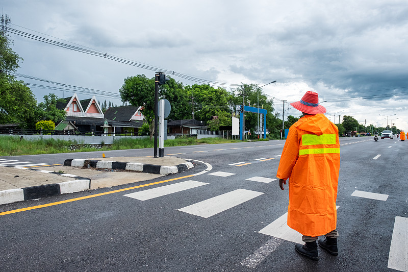 身穿橙色制服的交通官员控制和指挥乡村交通图片下载