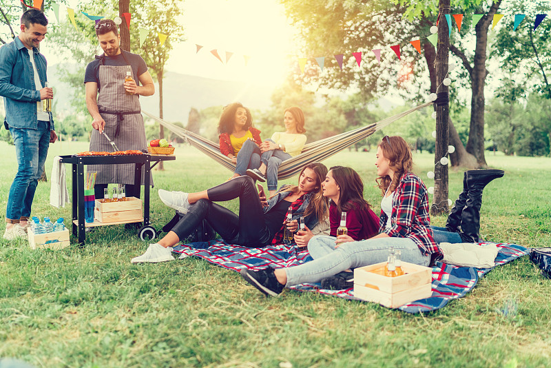 朋友们在公园里享受野餐和烧烤图片素材