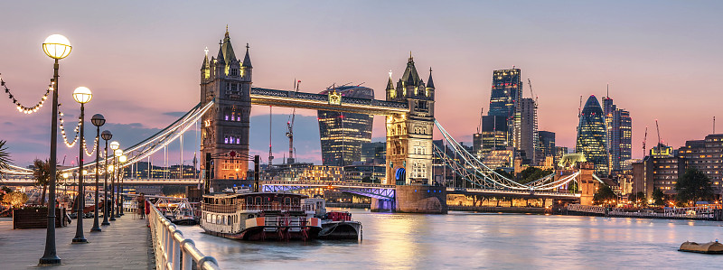 黄昏时分，灯火通明的塔桥和伦敦城的标志性建筑的全景图片素材