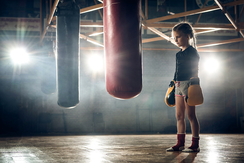 专心致志的小女孩准备在健身俱乐部进行拳击训练。图片下载