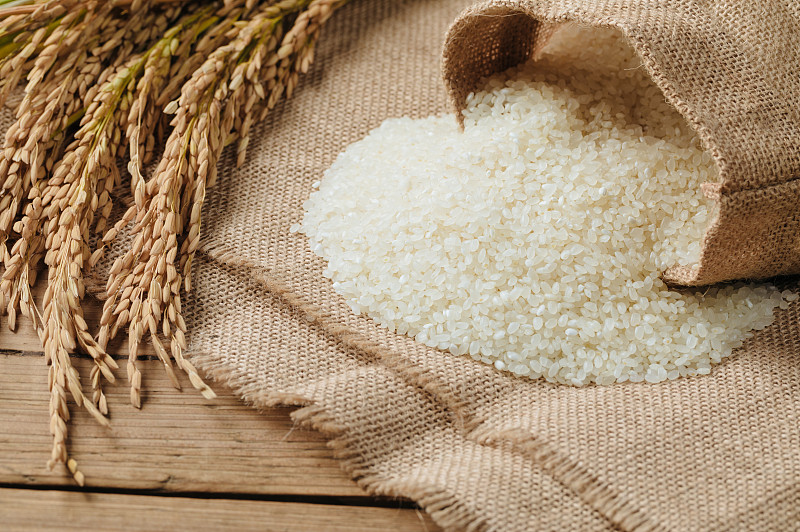 生米粒和干稻秆放在木桌上图片下载
