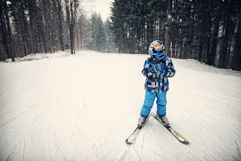 一个小男孩在一个美丽的冬日滑雪图片下载