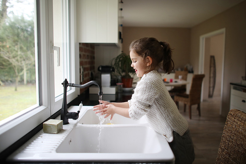 一个小女孩在厨房洗手图片下载
