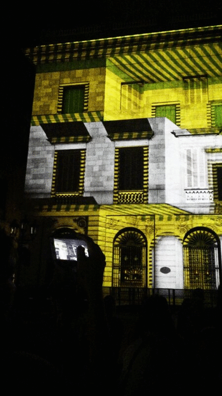 西班牙巴塞罗那，一名拍摄夜间广场灯光秀的人图片下载
