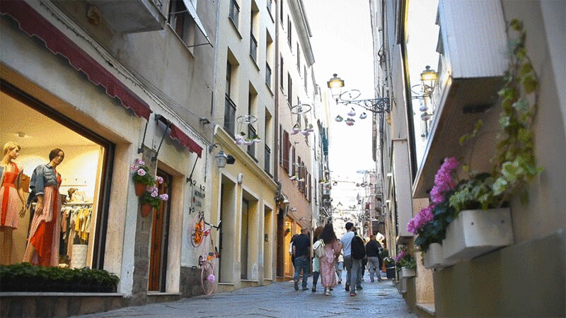游客穿过撒丁岛阿尔盖罗的窄街插画下载