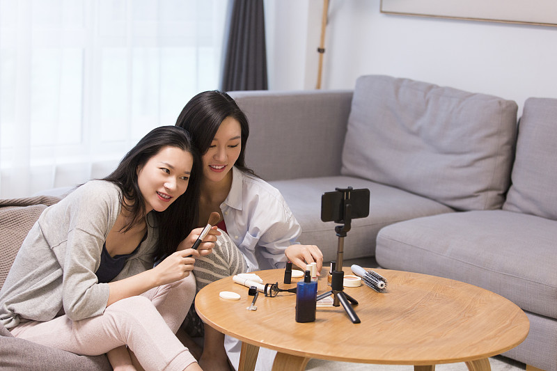 两个青年女子在客厅化妆做网络直播图片下载