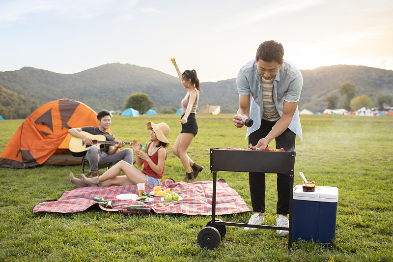 快乐的年轻朋友在户外野餐图片下载