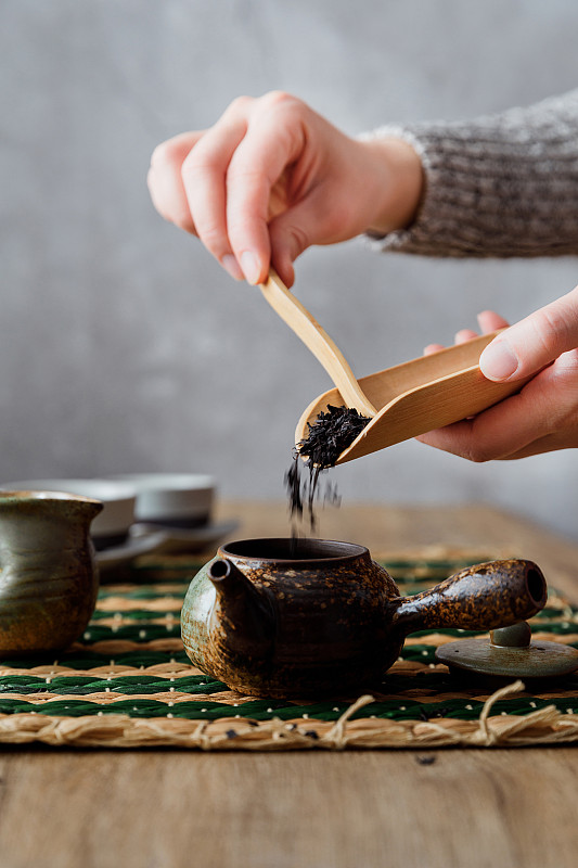 用茶匙把中国茶叶从茶荷里拨入茶壶图片下载