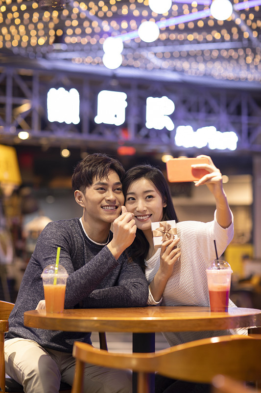 快乐的年轻情侣在商场自拍图片下载