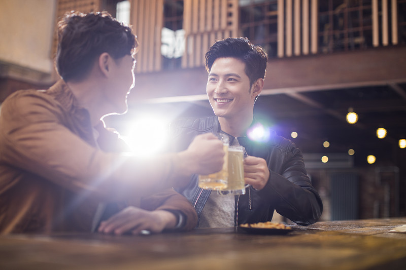 快乐的年轻男士在酒吧喝酒干杯图片下载