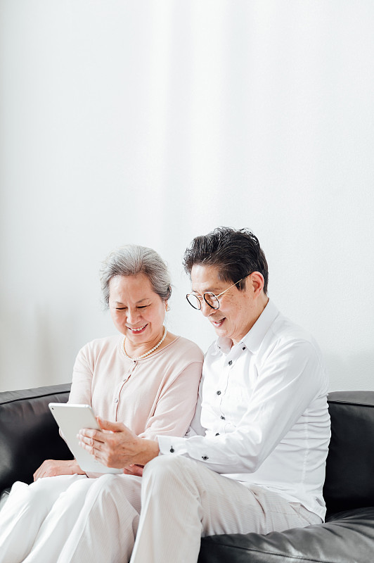 亚洲老年夫妇使用平板电脑图片素材