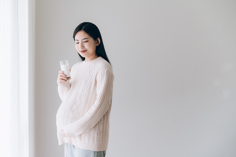 亚洲年轻孕妇喝牛奶图片素材