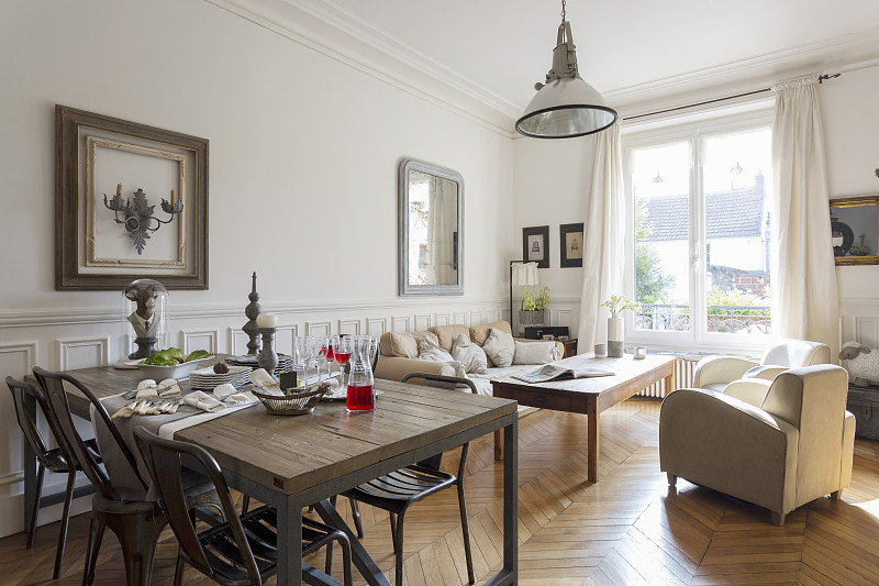 质朴的餐桌和苍白的沙发设置在房间与白色的墙壁图片下载