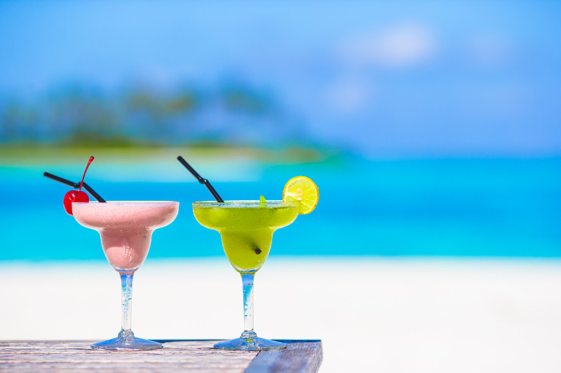 热带沙滩上两杯美味的鸡尾酒图片素材