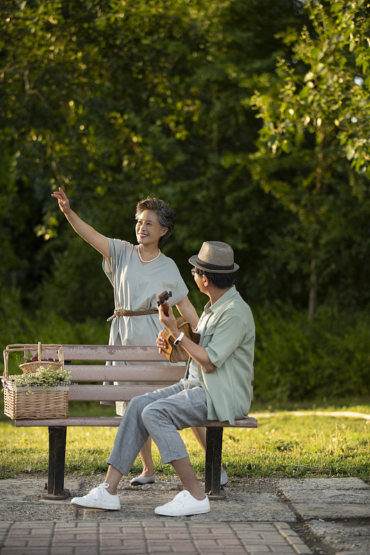 老年伴侣在户外弹琴和跳舞图片素材