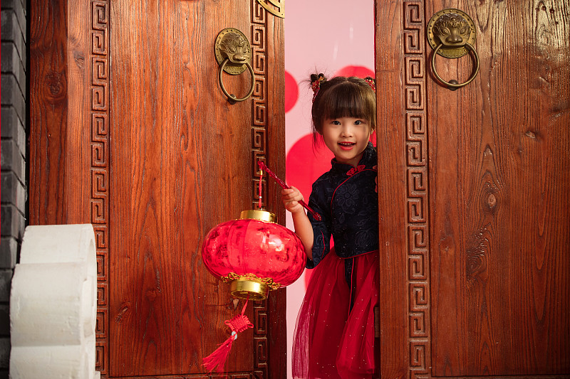 漂亮的小女孩手提红灯笼庆祝新年图片素材