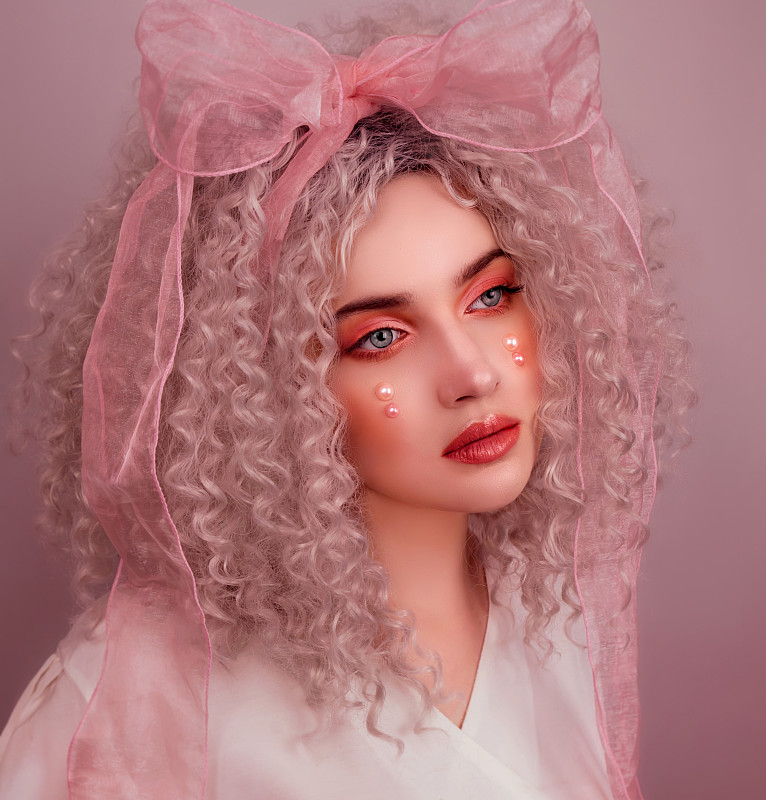 这是塞尔维亚的一个年轻女子的肖像，她有着粉红色的头发和化妆，背景是粉红色的图片下载