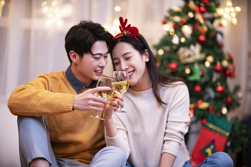 年轻夫妇在家喝香槟过圣诞节图片下载