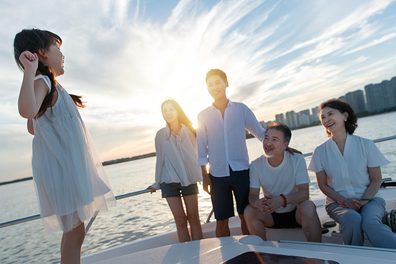 夕阳下在游艇上的快乐一家人图片素材