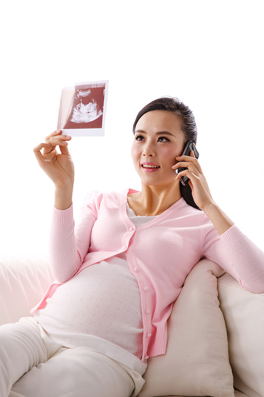 孕妇坐在沙发上打电话图片下载