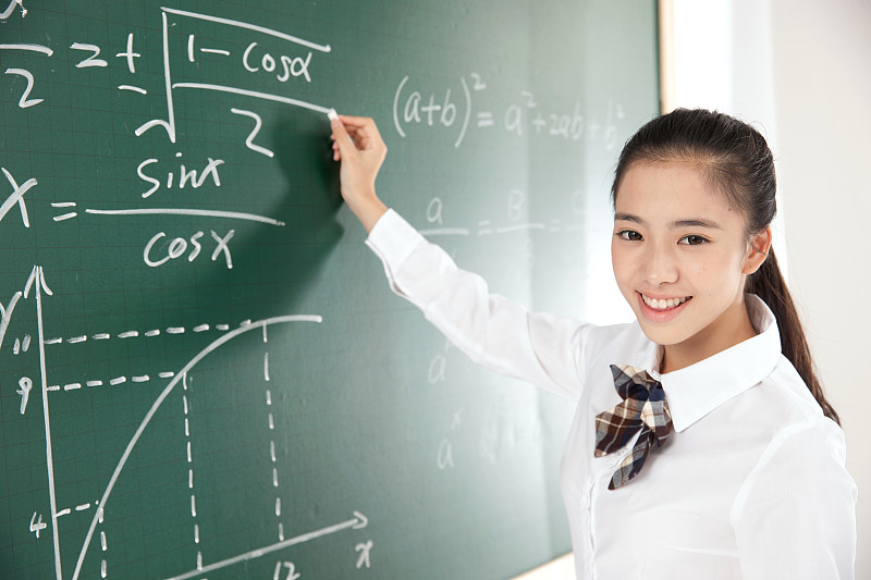 中学女生在黑板前写数学公式图片下载
